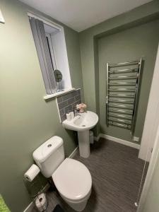 a bathroom with a white toilet and a sink at Coronation Court in Stoke on Trent