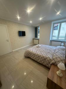 Un dormitorio con una cama y un televisor de pantalla plana. en Tre Regine, en Nápoles