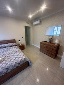 Un dormitorio con una cama y un televisor de pantalla plana. en Tre Regine, en Nápoles