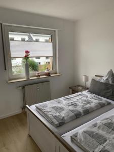 a bedroom with a large bed and a window at Ferienwohnung Sieben, Zentral gelegene mit Tiefgaragenstellplatz in Bad Oeynhausen