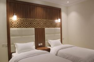 two beds sitting next to each other in a room at AL Tamayoz Al Raqi - Alfaisaliyah branch in Jeddah