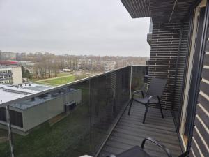 a balcony with a chair on top of a building at New Kreves apartment & Free parking & Self check-in in Kaunas +2 photos