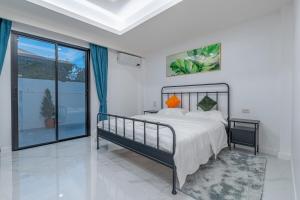 una camera da letto con un letto e una grande finestra di 芭提雅市中心 现代轻奢 独栋双层泳池别墅 五房六卫 全新 大空间 a Jomtien Beach