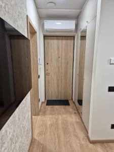 a hallway with a wooden door in a building at New Kreves apartment & Free parking & Self check-in in Kaunas