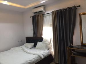 a bedroom with two beds and a window with curtains at Babcock University House in Lagos