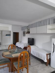 a room with two beds and a table and chairs at Loft con pileta en Barrio San Carlos Mar del Plata in Mar del Plata