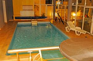 una piscina con mesa y sillas en una habitación en Apartments Villa Ceres, en Klek