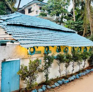 阿姆波尔Viik wellness inn -3 Star Resort in Arambol Beach的一座有蓝色屋顶的建筑,上面有植物
