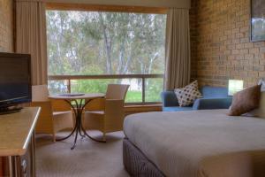 ein Hotelzimmer mit einem Bett und einem großen Fenster in der Unterkunft Mannum Motel in Mannum
