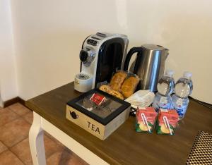 a table with a coffee maker and a box of tea at Appartamento ONE in Novara