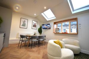 a living room with a table and chairs and skylights at CITYeSCAPE - 2BR Apt En-suite Sofa Bed NQ in Manchester