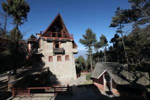 The End Of The Universe boutique hotel في ناغاركوت: مبنى حجري كبير مع شرفة فوقه