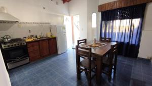 une cuisine avec une table, des chaises et un réfrigérateur dans l'établissement Cabaña de 1 habitacion en el centro de Choele ideal para 2 personas, à Choele Choel 6 autres photos