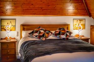 a bedroom with a bed with two lamps on night stands at The Hide in Hordle