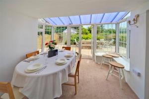Un comedor con una mesa y sillas blancas. en Ty Ffynnon, en Abersoch