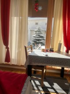 una mesa de comedor con un árbol de Navidad en la ventana en Bjelasnica, en Babin Do
