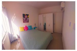 a small bedroom with a bed and a window at Apartamentos com 2 quartos na Praia de Itapema bairro Meia Praia in Itapema