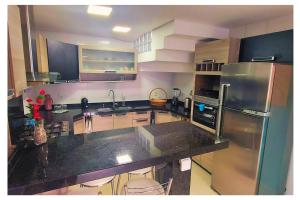 a kitchen with a stainless steel refrigerator and cabinets at Apartamentos com 2 quartos na Praia de Itapema bairro Meia Praia in Itapema