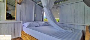 a bed in a room with a window at A Mango Tree House with a private swimming pool in Tegallengah