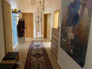 a hallway with a rug and a painting on the wall at Zweitbettzimmer Hannover in Hannover