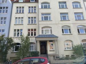 a building with a red car parked in front of it at Zweitbettzimmer Hannover in Hannover