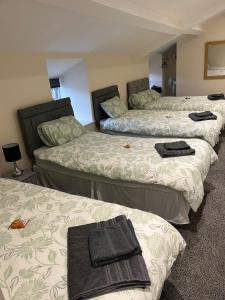 a group of three beds in a room at Coach & Horses Inn in Crickhowell
