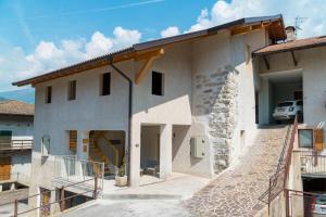 a large white house with a car parked at LE MUSE Comano Terme Holiday 2, primo piano in Comano Terme