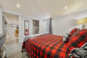 a bedroom with a bed with a red and black plaid blanket at Hidden Ranch in Sevierville