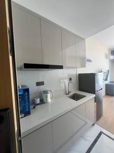 a white kitchen with a sink and a refrigerator at 17FL LUX Studio Room Apartment, Great View in Phnom Penh