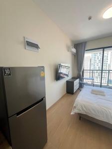 a room with a bed and a refrigerator in it at 17FL LUX Studio Room Apartment, Great View in Phnom Penh +4 photos