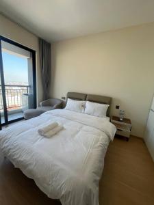 a large white bed in a room with a large window at 17FL LUX Studio Room Apartment, Great View in Phnom Penh