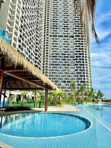 a swimming pool with a large building in the background at 17FL LUX Studio Room Apartment, Great View in Phnom Penh