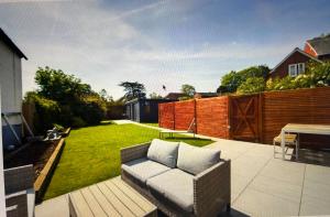 a couch sitting on a patio in a backyard at Blue Room in Pangbourne