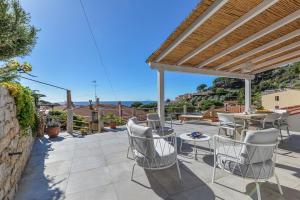 a patio with chairs and a table and a pergola at Casa Melete - Goelba in Seccheto