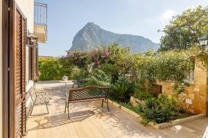 a bench sitting on a patio with a mountain in the background at Casa Vacanza Azzurra in San Vito lo Capo