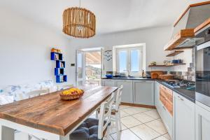 a kitchen with a wooden table with a bowl of fruit on it at Casa Melete - Goelba in Seccheto +23 photos
