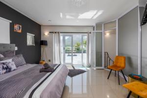 a bedroom with a large bed and a chair at Bed and Breakfast Villa Livadia in Cape Town +78 photos