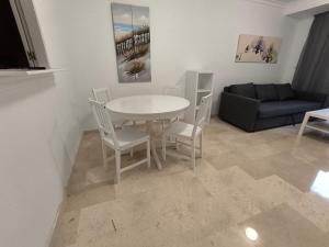 Una sala de estar con una mesa y sillas y un sofá. en Elviria, en Marbella 16 fotos más