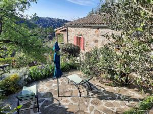 eine Terrasse mit zwei Stühlen und einem Sonnenschirm in der Unterkunft La calade de Joux in Chassiers