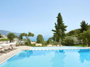 a large swimming pool with a view of the ocean at Grecotel Daphnila Bay in Dassia +77 photos