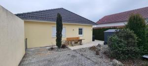 a yellow house with a bench in front of it at Ferienwohnung Delja in Aulendorf