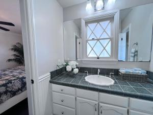 a bathroom with a sink and a window and a bed at Destination #22 in Anaheim +25 photos