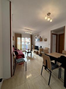 ein Wohnzimmer mit Sofa und Tisch in der Unterkunft Apartamento vacacional cerca al mar - OROPESA DEL MAR in Oropesa del Mar