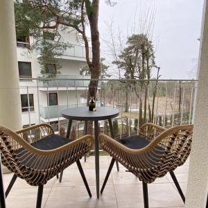 ein Tisch und Stühle auf einem Balkon mit Fenster in der Unterkunft Apartament Capri z widokiem na morze- Krynica Morska in Krynica Morska