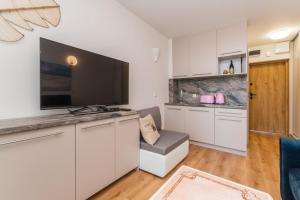 ein Wohnzimmer mit einem großen Flachbildfernseher in der Unterkunft Apartament Capri z widokiem na morze- Krynica Morska in Krynica Morska