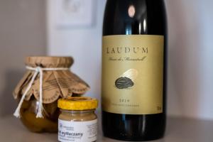 eine Flasche Wein neben einem Glas Honig in der Unterkunft Apartament Capri z widokiem na morze- Krynica Morska in Krynica Morska + 5 Fotos