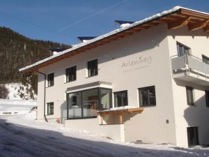 a building with a sign on it in the snow at Arlenweg in Sankt Anton am Arlberg