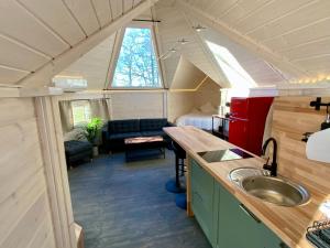 a kitchen and living room in a tiny house at La Cabane perchée du Grand Chêne in Bongheat