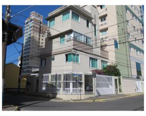 un alto edificio bianco con una recinzione bianca di Apartamentos com 2 quartos Praia de Itapema a Itapema Altre 57 foto