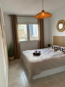 a bedroom with a large bed with a chandelier at Appartement Calpe ApoloV Ibiza Style in Calpe